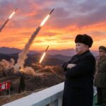 ผู้นำเกาหลีเหนือยืนกอดอกแล้วมีขีปนาวุธถูกยิงขึ้นฟ้าหลายลูก