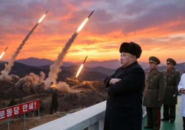 ผู้นำเกาหลีเหนือยืนกอดอกแล้วมีขีปนาวุธถูกยิงขึ้นฟ้าหลายลูก
