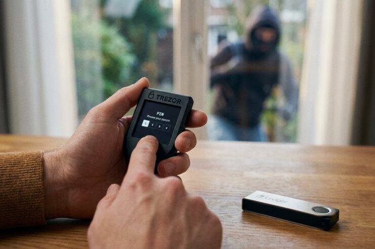 ภาพคนกำลังใช้งาน Hardware Wallet ในบ้าน แล้วมีโจรย่องอยู่นอกบ้านลาง ๆ โดยZoom ให้เห็นว่ามือกำลังกด Hardware Wallet อยู่จริง ๆ